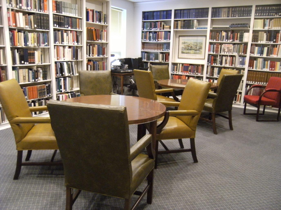 Photograph of the C. E. Campbell Beall Room. Shows the bookcases on the walls, the computer in the corner, and the seating.
